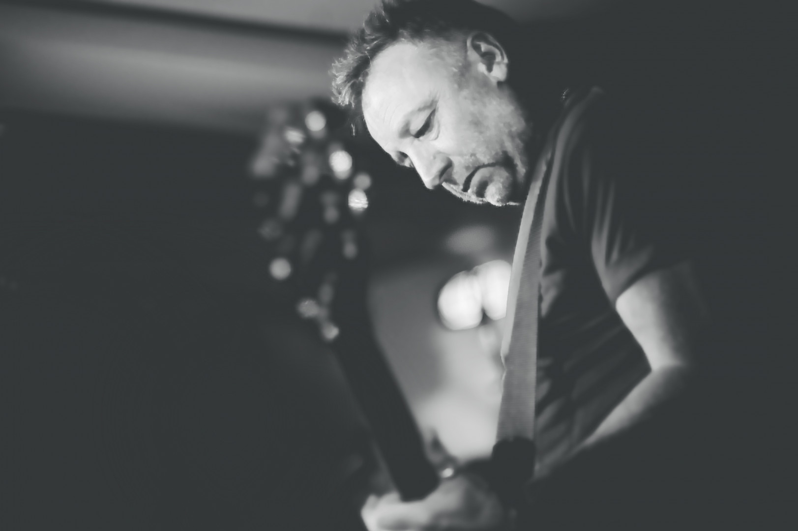 Un musicista suona la chitarra durante un concerto dal vivo.